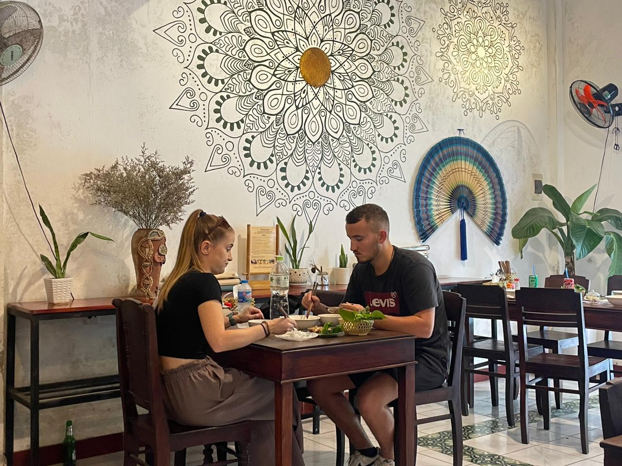 Couple enjoying lunch under the mandala wall at our restaurant